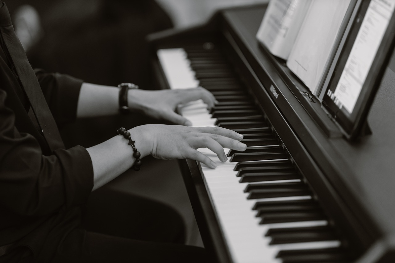 Woman playing piano and looking at lead sheet book